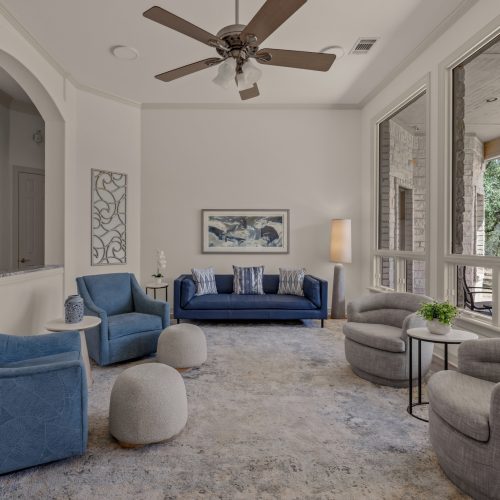 Living room with blue sofas, accent chairs and ceiling fan at 133 Forest Trail in Leander, TX